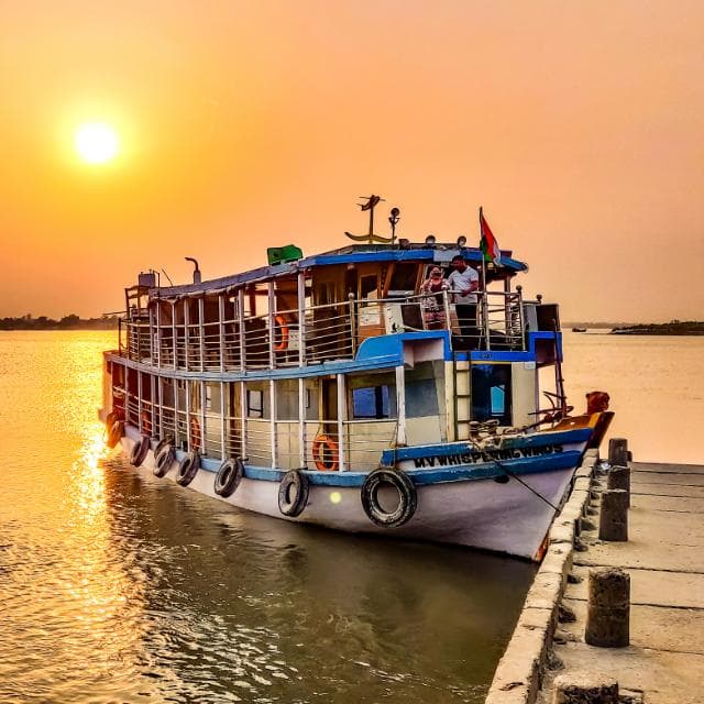 Whispering Winds houseboat at the Sundarban river during sunset