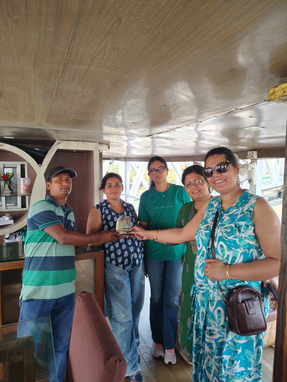 Ladies group aboard Whispering Winds receiving a memento from a crew member
