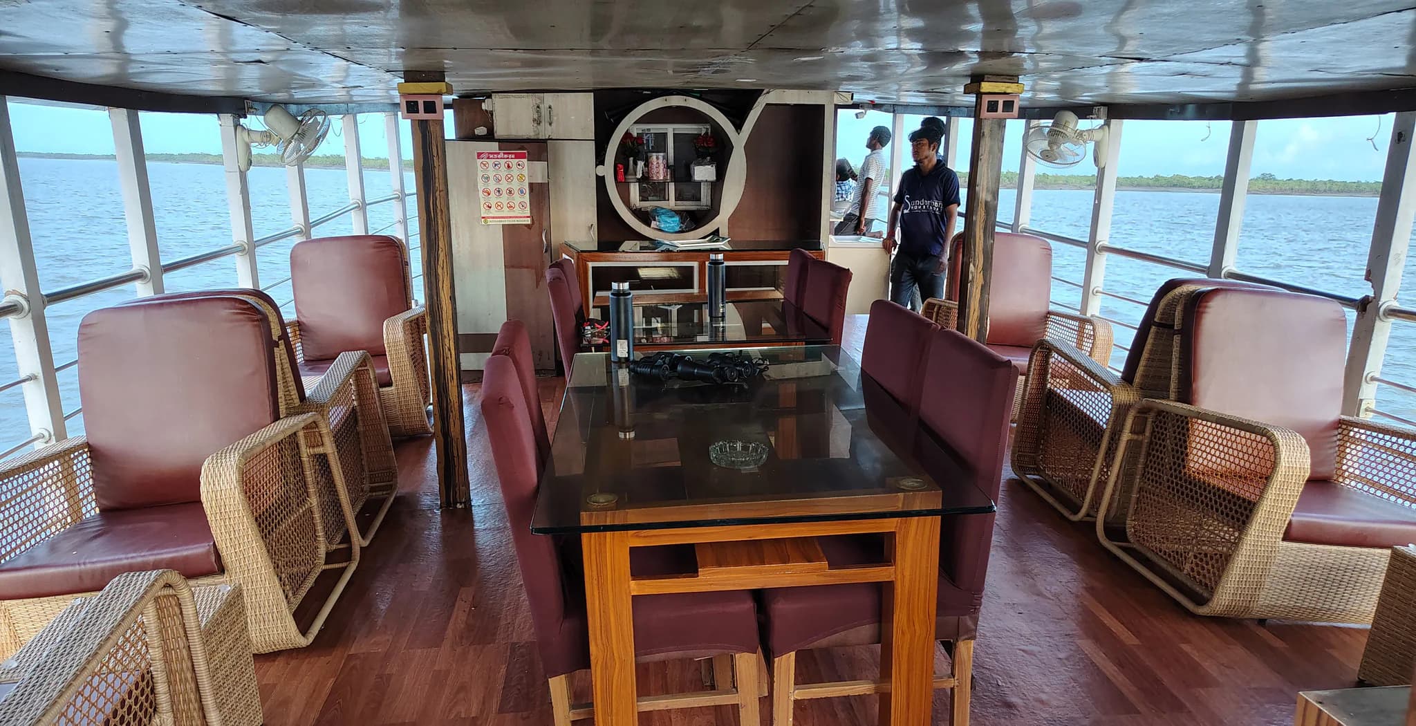 Open upper-deck seating and dining area aboard Whispering Winds