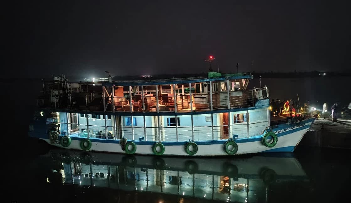 Whispering Winds houseboat illuminated at night on the Sundarban waterways